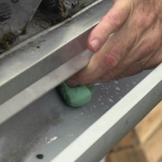 Laga hängrännan: Skrubba hängrännan med en svamp Laga hängrännan: Skrubba hängrännan med en svamp